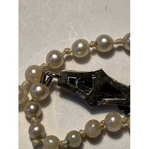 511A - A STRING OF PEARLS WITH A 9 CARAT WHITE GOLD AND DIAMOND CLASP