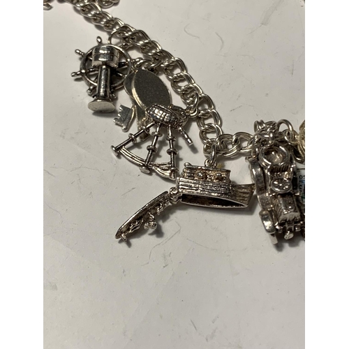 681A - A SILVER CHARM BRACELET WITH FOURTEEN CHARMS