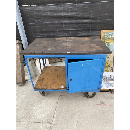 2011 - A METAL FOUR WHEELED WORKSHOP TROLLEY WITH LOWER CUPBOARD AND WOODEN WORK TOP