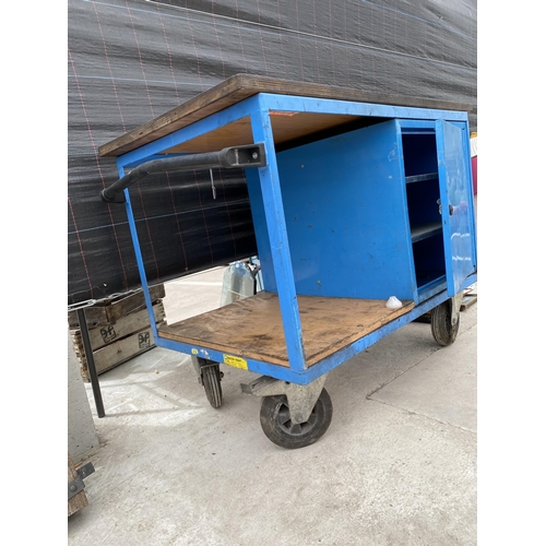 2011 - A METAL FOUR WHEELED WORKSHOP TROLLEY WITH LOWER CUPBOARD AND WOODEN WORK TOP