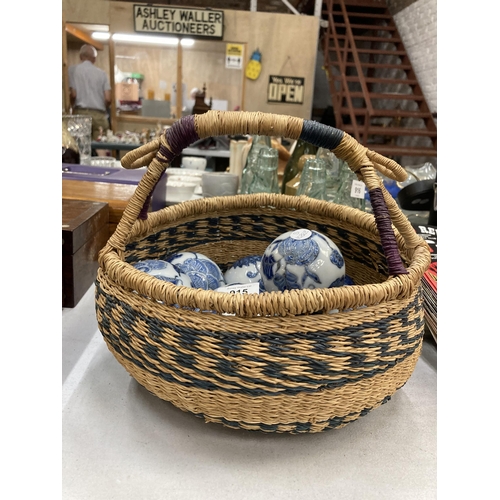 915 - A QUANTITY OF CERAMIC BLUE AND WHITE ORNAMENTAL BALLS IN A VINTAGE BASKET