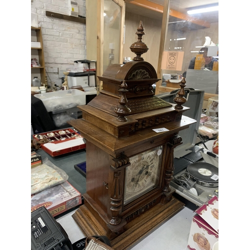 941 - A LARGE MAHOGANY CASED MANTLE CLOCK WITH COLUMN CARVING, IN NEED OF RESTORATION