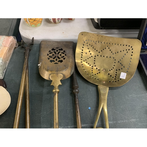 946 - FOUR LARGE PIECES OF BRASSWARE TO INCLUDE A POKER, TONGS, SKILLET AND SHOVEL