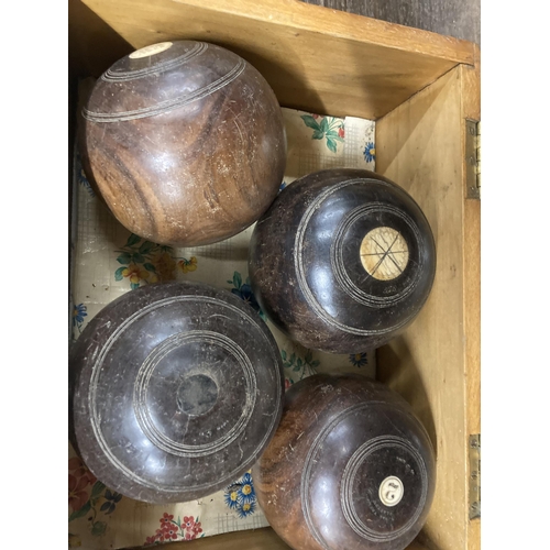 1036 - A VINTAGE PINE BOX CONTAINING FOUR BOWLING BOWLS