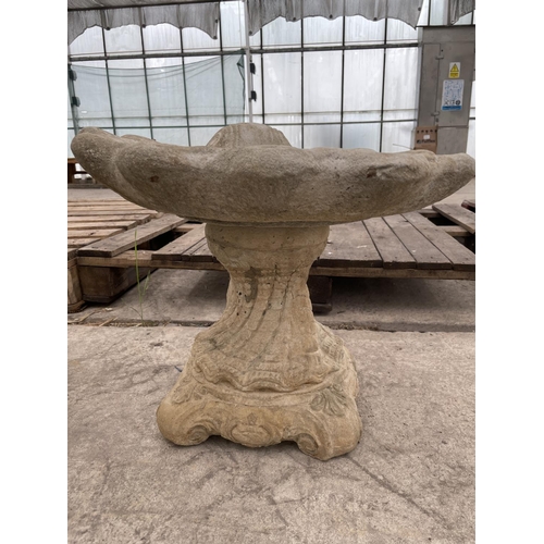 134 - A CONCRETE SHELL BIRDBATH WITH A DECORATIVE BASE NO VAT