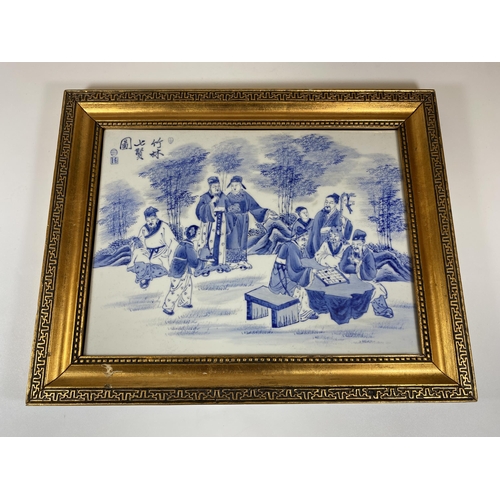 386 - A GILT FRAMED CHINESE BLUE AND WHITE PORCELAIN PLAQUE WITH SCHOLAR FIGURES DESIGN, SIGNED TO TOP LEF... 