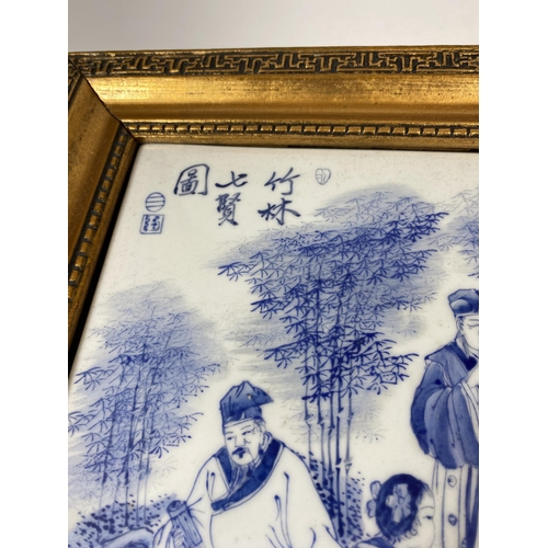 386 - A GILT FRAMED CHINESE BLUE AND WHITE PORCELAIN PLAQUE WITH SCHOLAR FIGURES DESIGN, SIGNED TO TOP LEF... 