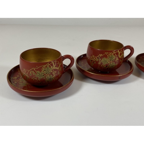 465 - A SET OF FOUR ORIENTAL RED AND GILT LACQUERED CUPS AND SAUCERS, SAUCER DIAMETER 9.5CM