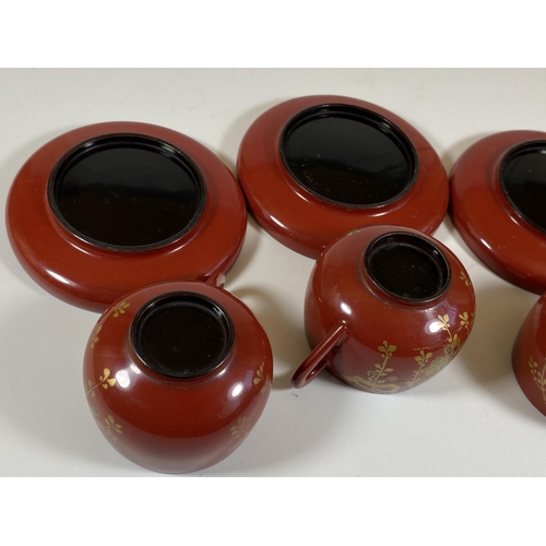 465 - A SET OF FOUR ORIENTAL RED AND GILT LACQUERED CUPS AND SAUCERS, SAUCER DIAMETER 9.5CM