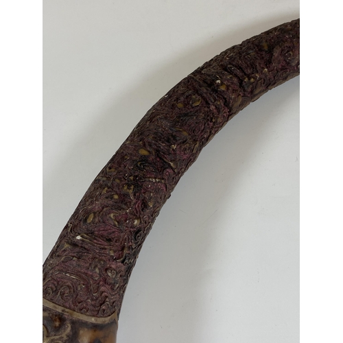 481 - AN ORIENTAL CAVRED RESIN HORN, LENGTH APPROX 42CM