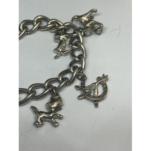 530 - A SILVER CHARM BRACELET WITH TEN CHARMS AND A HEART PADLOCK