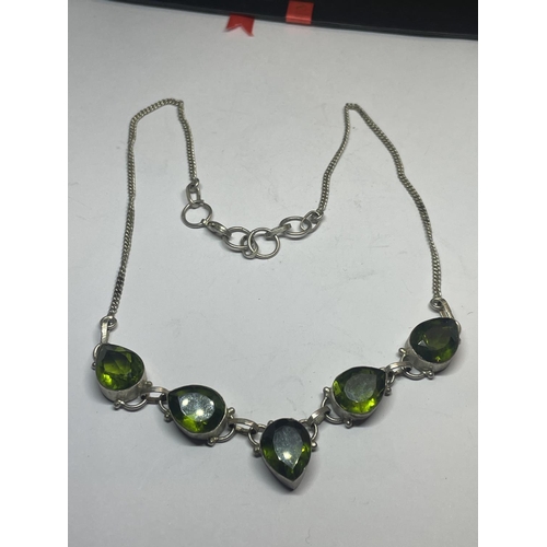 550 - A SILVER NECKLACE WITH FIVE LARGE TEARDROP SHAPED GREEN STONES IN A PRESENTATION BOX