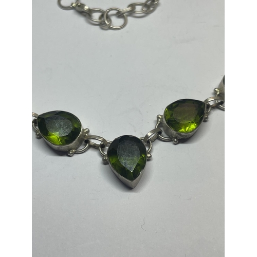 550 - A SILVER NECKLACE WITH FIVE LARGE TEARDROP SHAPED GREEN STONES IN A PRESENTATION BOX