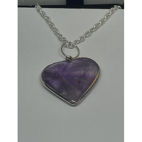 568 - A SILVER NECKLACE WITH A PURPLE STONE HEART SHAPED PENDANT IN A PRESENTATION BOX