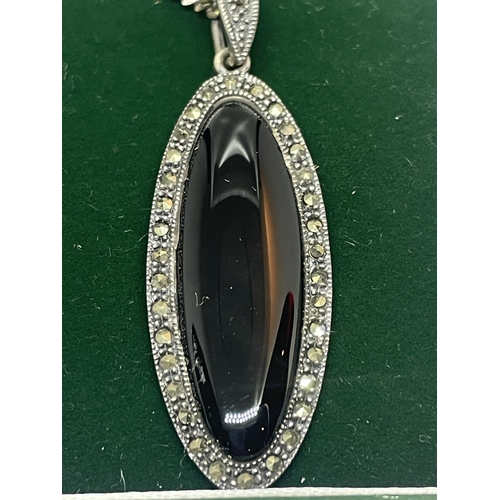 584 - A SILVER NECKLACE WITH AN OVAL PURPLE STONE AND MARCASITE PENDANT IN A PRESENTATION BOX