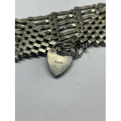 627 - A SILVER SEVEN BAR GATE BRACELET WITH HEART PADLOCK AND A SILVER WEAVE DESIGN BANGLE