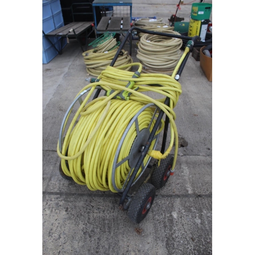 29 - A LARGE MARKET GARDENERS HOSE AND FOUR WHEELED TROLLEY REEL NO VAT