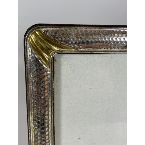 31 - A VINTAGE HAMMERED WHITE METAL PHOTO FRAME, POSSIBLY SILVER BUT UNMARKED, 22 X 17CM