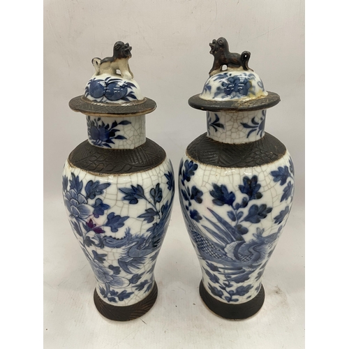 41 - A PAIR OF LATE 19TH CENTURY CHINESE CRACKLE GLAZE BLUE AND WHITE LIDDED TEMPLE VASES, SEAL MARKS TO ... 