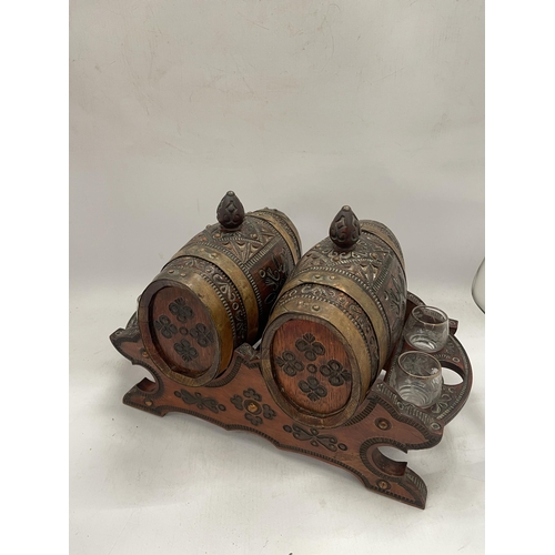 44 - A VINTAGE CARVED WOODEN NORTH AFRICAN DRINKS DISPENSER WITH GLASSES