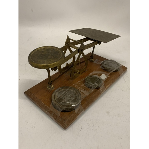 136 - A SET OF BRASS AND WOOD POST OFFICE SCALES WITH WEIGHTS