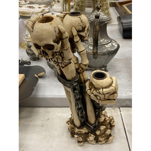 173 - A RESIN SKELETON CANDLESTICK HEIGHT 34CM, A SKELETON BRIDE AND GROOM AND TWO TANKARDS