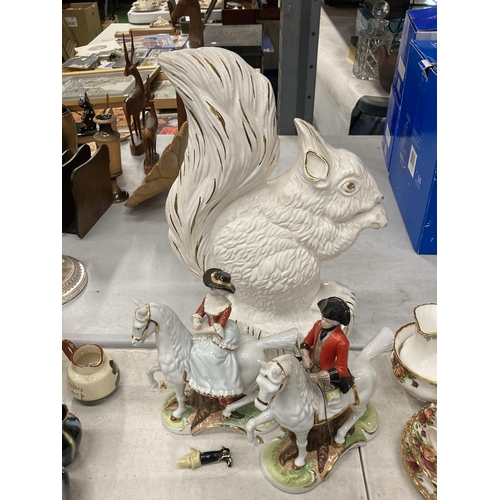 831 - A LARGE WHITE CERAMIC SQUIRREL AND TWO CONTINENTAL FIGURES