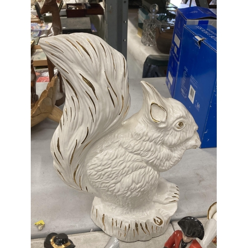 831 - A LARGE WHITE CERAMIC SQUIRREL AND TWO CONTINENTAL FIGURES