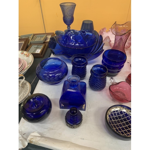 411 - A LARGE QUANTITY OF VINTAGE CRANBERRY AND BLUE GLASS TO INCLUDE BOWLS, VASES, JUGS, ETC