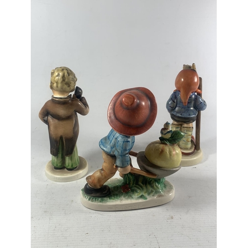 754 - THREE WESTERN GERMAN FIGURES TO INCLUDE A BOY WITH A WHEELBARROW, A TELEPHONE ETC