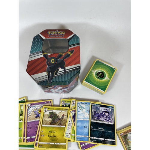 102 - AN UMBREON TIN OF POKEMON TRADING CARDS, HOLOS ETC