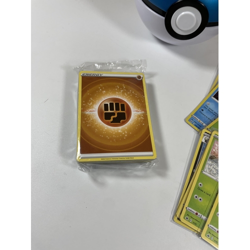 103 - A POKE BALL TIN OF POKEMON TRADING CARDS, HOLOS, PIKACHU GX, SEALED ENERGY PACK ETC