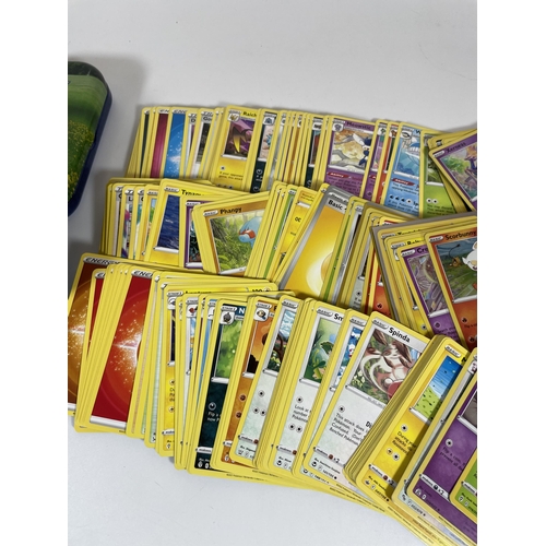 105 - THREE TINS OF ASSORTED POKEMON TRADING CARDS, HOLOS ETC