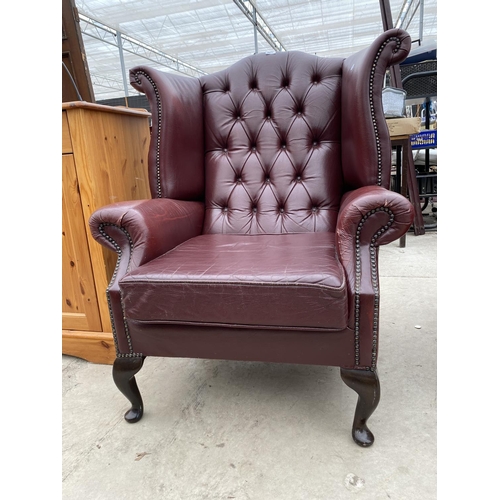 2811 - A RED LEATHER WINGED FIRESIDE CHAIR ON CABRIOLE LEGS