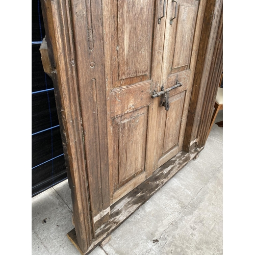 2848 - A PAIR OF INDIAN HARDWOOD PANELLED DOORS WITH BRASS FITTINGS + CARVED CORNICE, 84 X 58