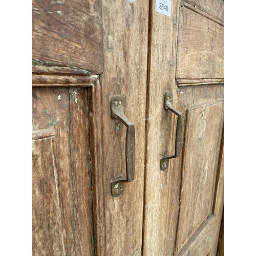 2848 - A PAIR OF INDIAN HARDWOOD PANELLED DOORS WITH BRASS FITTINGS + CARVED CORNICE, 84 X 58