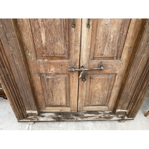 2848 - A PAIR OF INDIAN HARDWOOD PANELLED DOORS WITH BRASS FITTINGS + CARVED CORNICE, 84 X 58