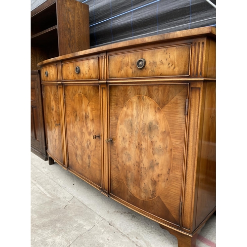 2868 - A YEW WOOD CROSSBANDED BOW FRONTED 'RACKSTRAW' SIDEBOARD ENCLOSING THREE DRAWERS AND THREE CUPBOARDS... 