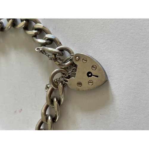 556 - A HEAVY SILVER BRACELET WITH HEART PADLOCK