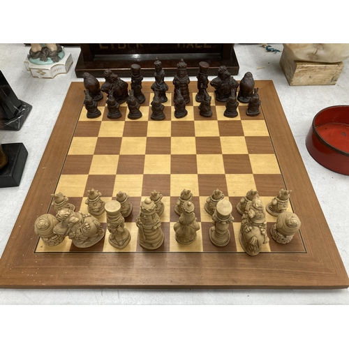 31 - A CHESS SET WITH A WOODEN BOARD AND ALICE IN WONDERLAND THEMED PLAYING PIECES