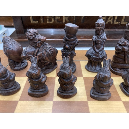 31 - A CHESS SET WITH A WOODEN BOARD AND ALICE IN WONDERLAND THEMED PLAYING PIECES