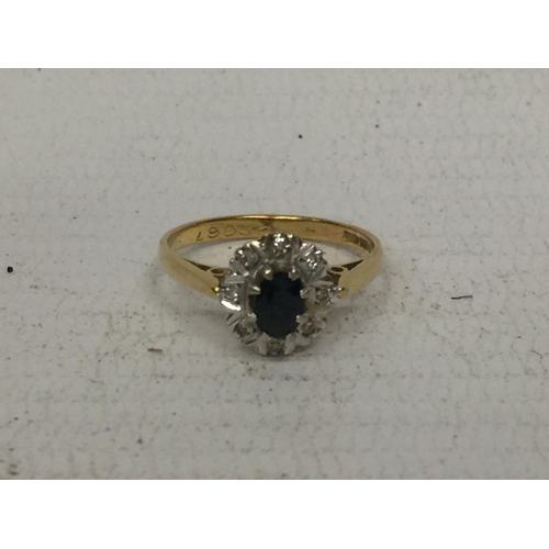 502 - AN 18CT RING WITH CENTRE DARK STONE  (POSSIBLY SAPPHIRE) SURROUNDED BY DIAMOND CHIPS