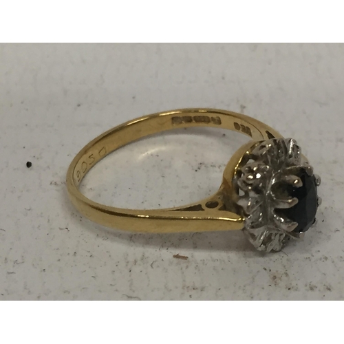 502 - AN 18CT RING WITH CENTRE DARK STONE  (POSSIBLY SAPPHIRE) SURROUNDED BY DIAMOND CHIPS