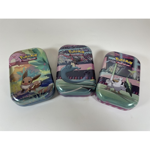 126 - THREE TINS OF ASSORTED POKEMON CARDS, HOLOS SQUIRTLE, MOLTRES ETC