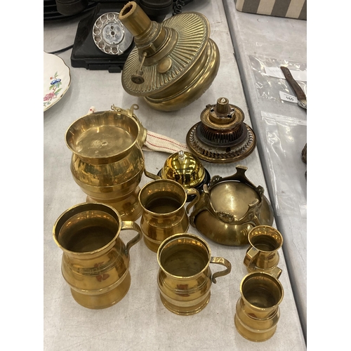 162 - A QUANTITY OF BRASSWARE TO INCLUDE TANKARDS OF VARYING SIZES, A COUNTER BELL, OIL LAMP PARTS, ETC