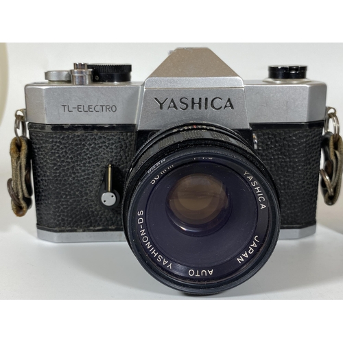 133 - TWO VINTAGE CAMERAS - YASHICA TL-ELECTRO FITTED WITH A YASHICA AUTO 50MM LENS AND A MINOLTA XG2 BODY