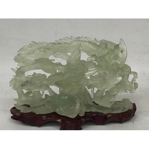 439 - A CHINESE JADE TYPE CARVING ON MODERN STAND