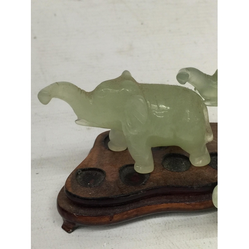 441 - A SET OF CHINESE JADE TYPE ELEPHANTS ON WOODEN STAND