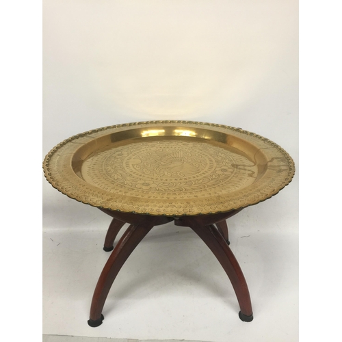 47 - A VINTAGE MIDDLE EASTERN DESIGN BRASS TRAY ON WOODEN STAND