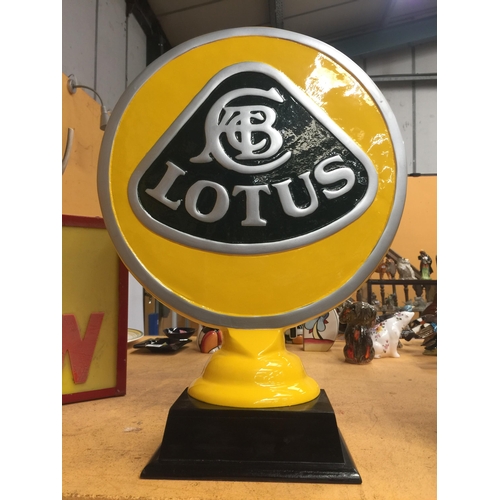 51 - A YELLOW METAL LOTUS SIGN ON WOODEN BASE